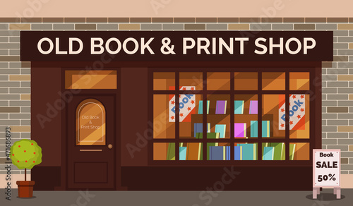 Vintage book shop store facade with storefront large window, columns and brick wall.