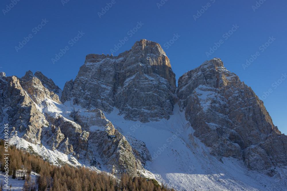 Italian mountains winter landscape. First snow fell on the Dolomites. View on mount Pelmo, Italy. Snow-capped mountains against the blue sky. Luca warm, particular. Concept of vacation in Italy.