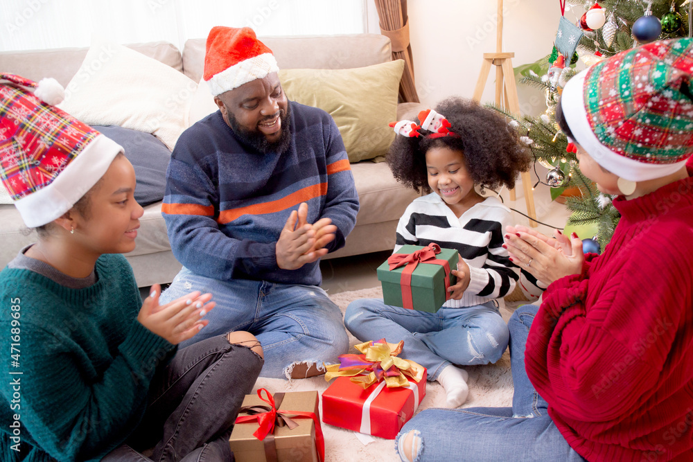 Happy family father and mother giving gift box with daughter on celebration in Christmas day at home, xmas with parent surprising children with enjoyment at house, thanksgiving eve, Merry Christmas. Happy family father and mother giving gift box with daughter on celebration in Christmas day at home, xmas with parent surprising children with enjoyment at house, thanksgiving eve, Merry Christmas.