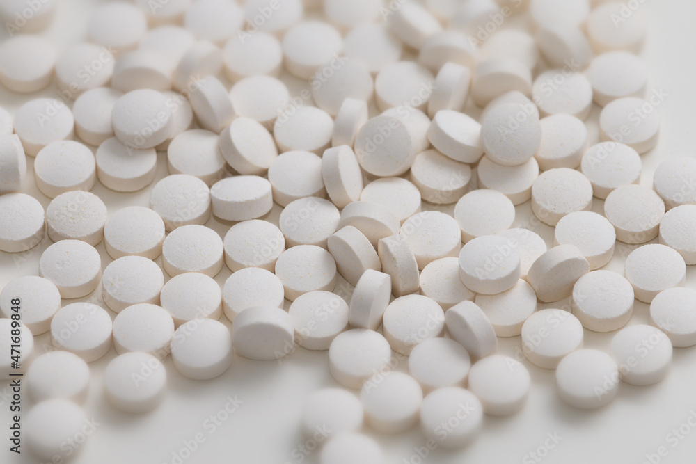 A lot of white round pills on white background. Vitamin pills. A lot of white round pills on white background. Vitamin pills.