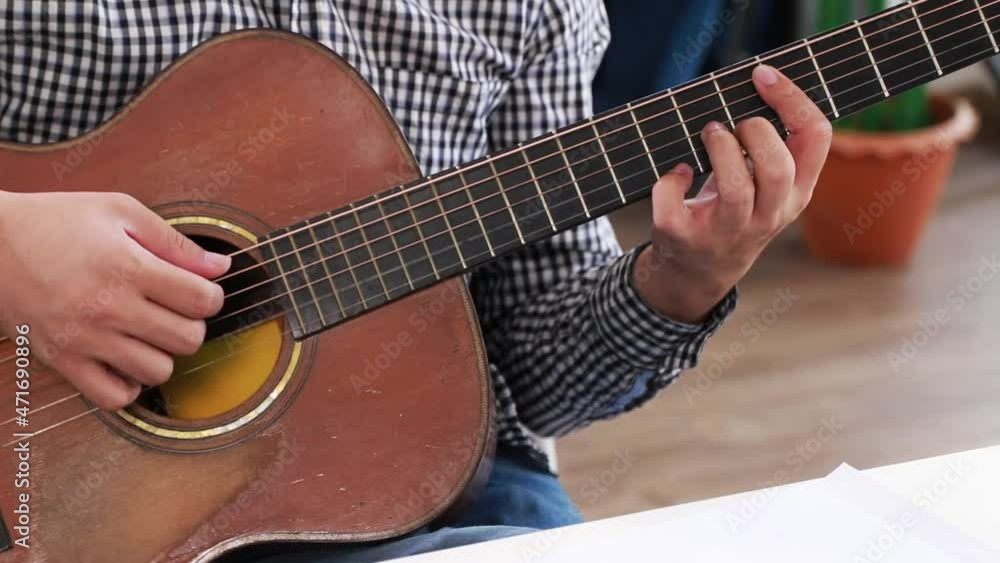 Hands of a classical guitar teacher playing acoustic guitar as an online classroom teaching. Hands of a classical guitar teacher playing acoustic guitar as an online classroom teaching.