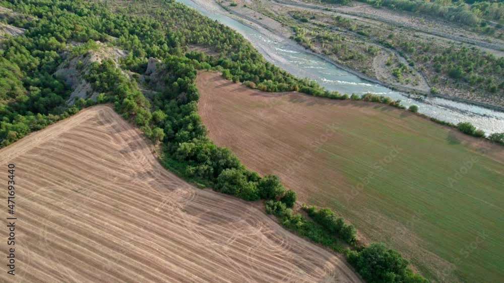 The mountain river meanders upwards among the trees. Top view of the river with many bends. The mountain river meanders upwards among the trees. Top view of the river with many bends.