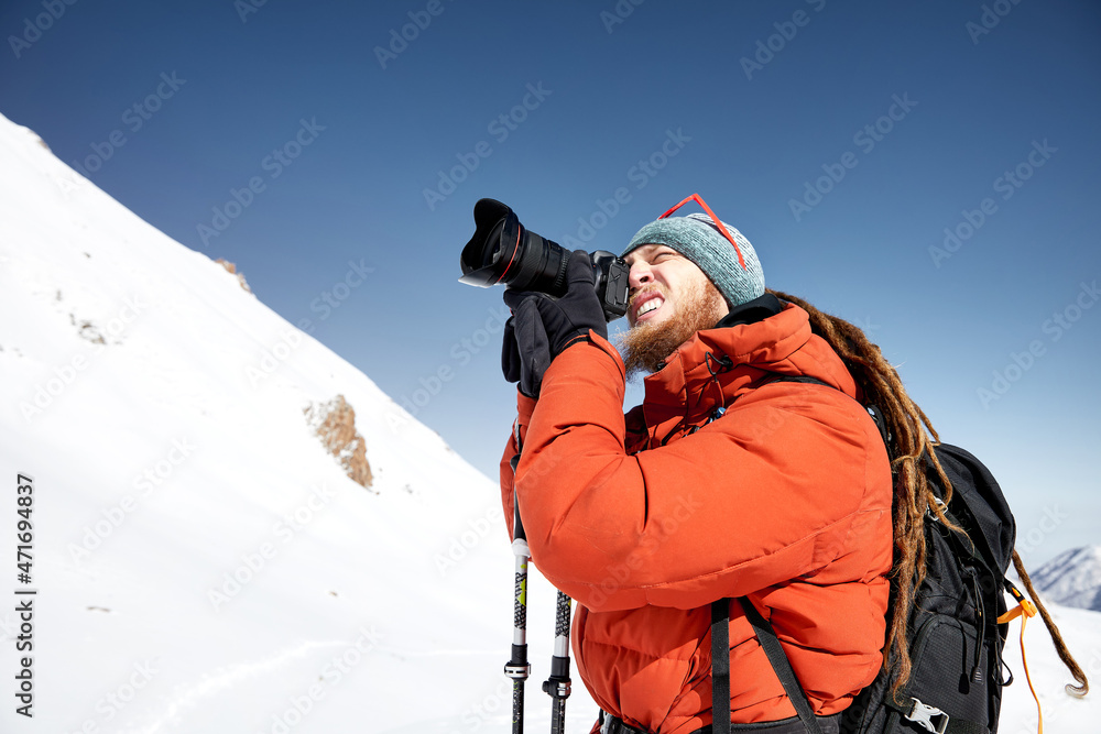 Photographer with dreadlock at beautiful mountain winter landscape