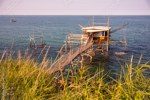 A traditional wooden fishing trabocco in the sea in Italy photo