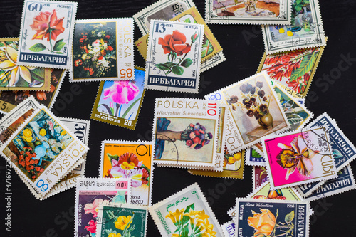 postage stamps isolated on a wooden background with the image of flowers, background, top view