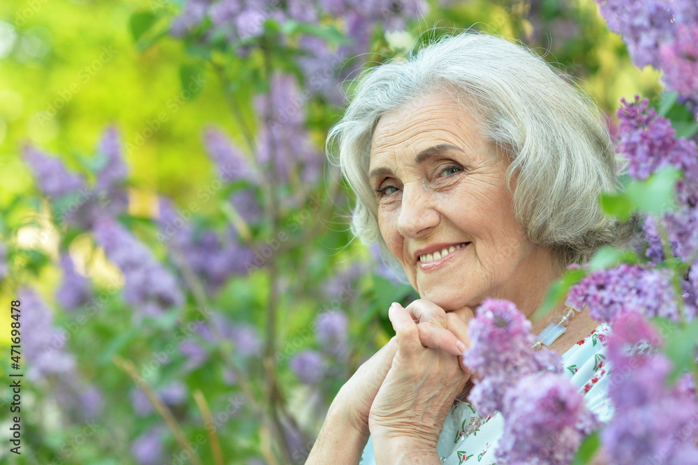 Obraz premium Portrait of happy senior beautiful woman on lilacs background