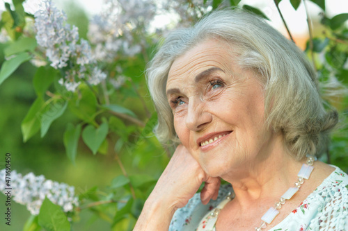 Portrait of happy senior beautiful woman on lilacs background