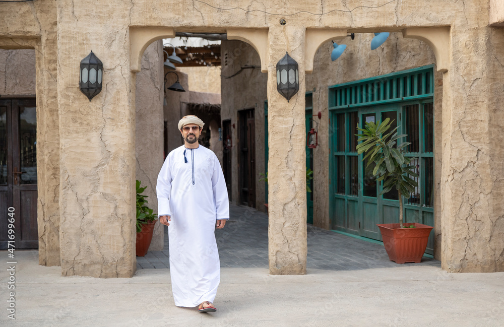 Naklejka premium Arab man walking in the alleys of al seef district in Dubai