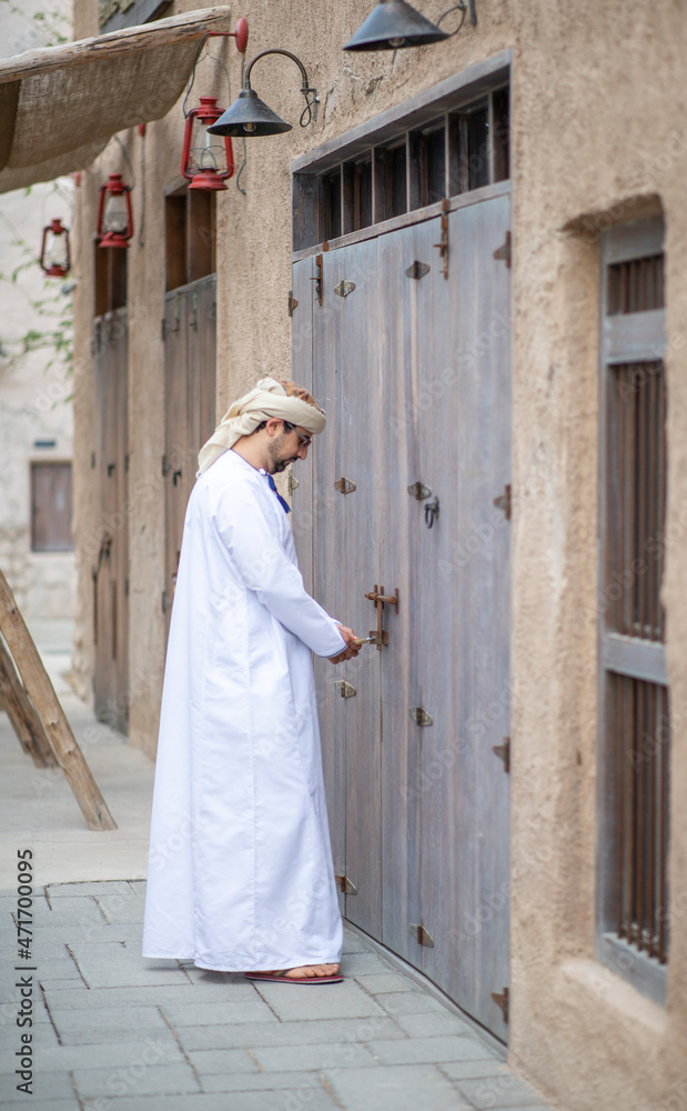 Arab man opening his shop in the alleys of al seef district in Dubai