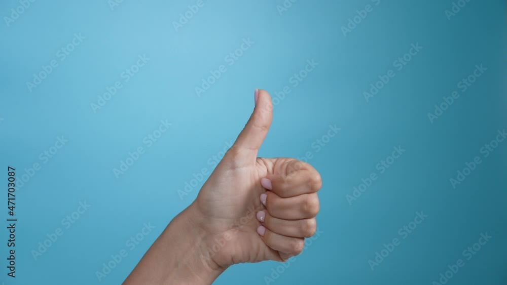 Woman showing thumb up gesture isolated on blue background Woman showing thumb up gesture isolated on blue background