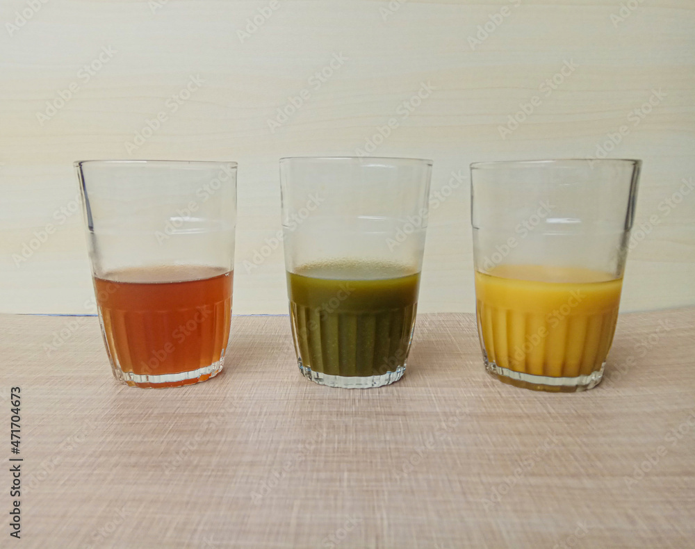 Jamu or herbal drink from Javanese culture, Indonesia. Each color made from different ingredient. Wooden background. Jamu or herbal drink from Javanese culture, Indonesia. Each color made from different ingredient. Wooden background.