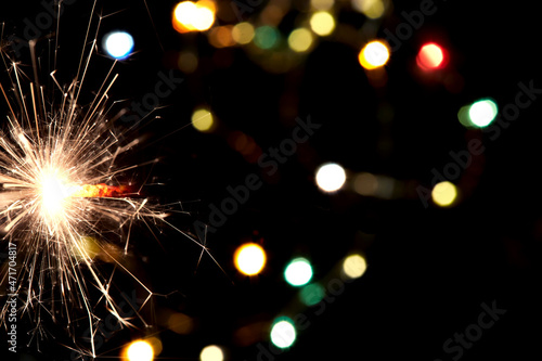 Bright holiday. Bengali fire burning on the background of beautiful bokeh. Concept Happy New Year and christmas.