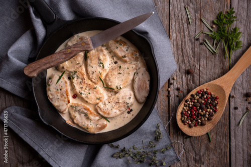 Cooked chicken breast with creamy sauce in frying pan