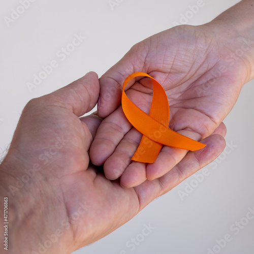 December orange	. man and woman holding orange ribbon. campaign to prevent skin cancer, melanoma