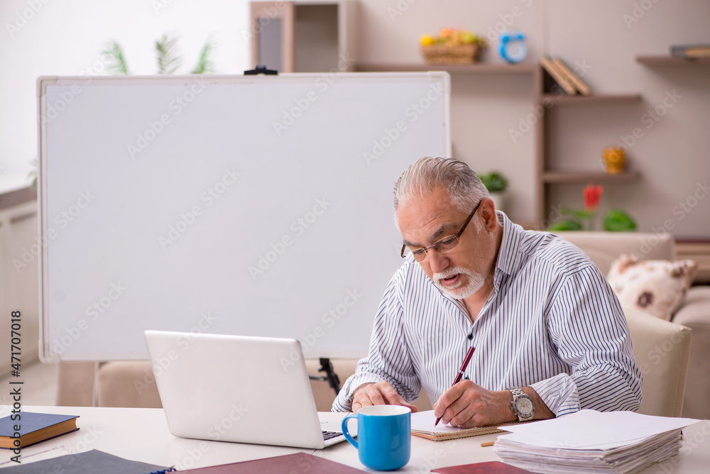 Old male employee working from home during pandemic