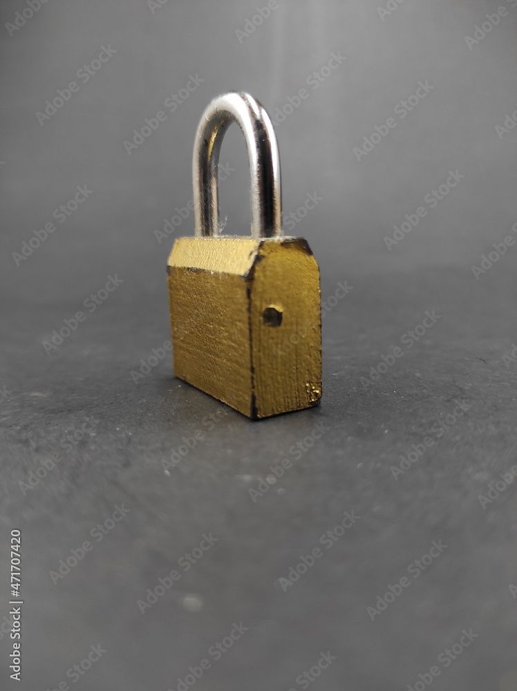 Fototapeta premium Photo of golden padlock isolated on black background, Not Focus