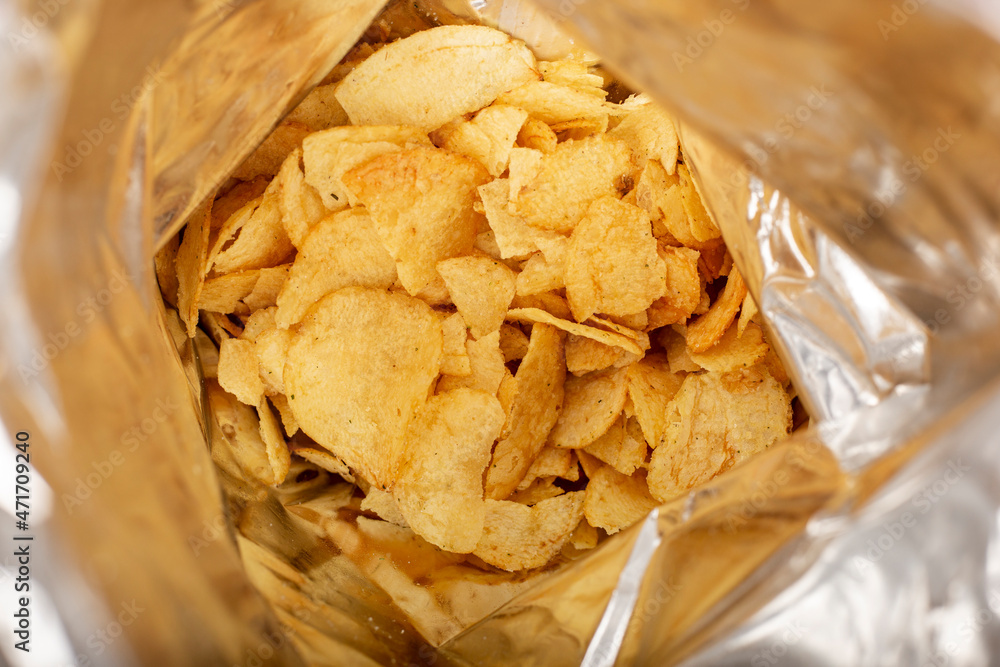 Open package with fresh potato chips. Top view, flat lay.