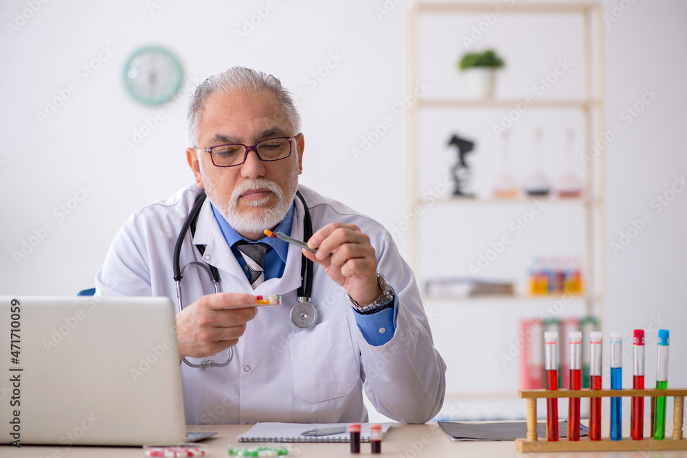 Old male doctor pharmacist working at the lab Old male doctor pharmacist working at the lab
