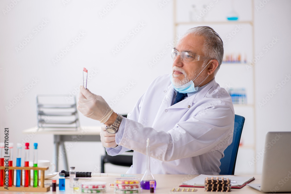 Old male chemist in drug synthesis concept Old male chemist in drug synthesis concept