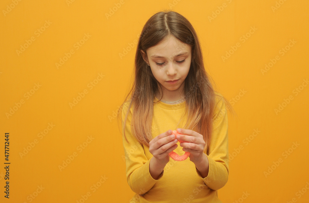 Little girl in yellow t-shirt playing with a slime Little girl in yellow t-shirt playing with a slime