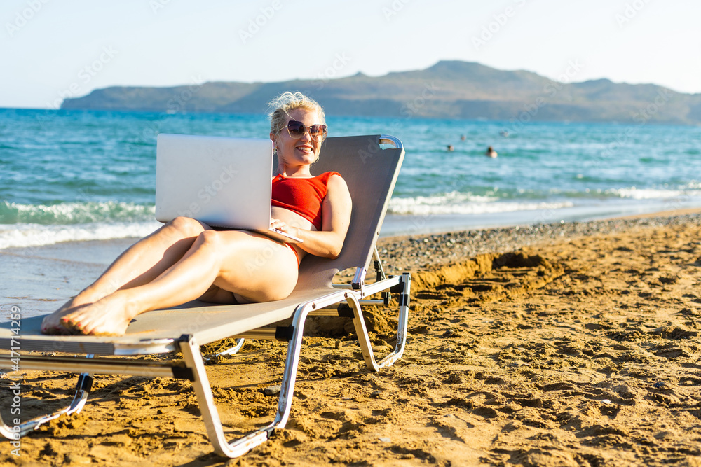 Beautiful Business Woman Working Online On Laptop Computer While Lying On Beach Lounger. Freelancer Girl Relaxing And Using Notebook Internet Work. Communication Technology.
