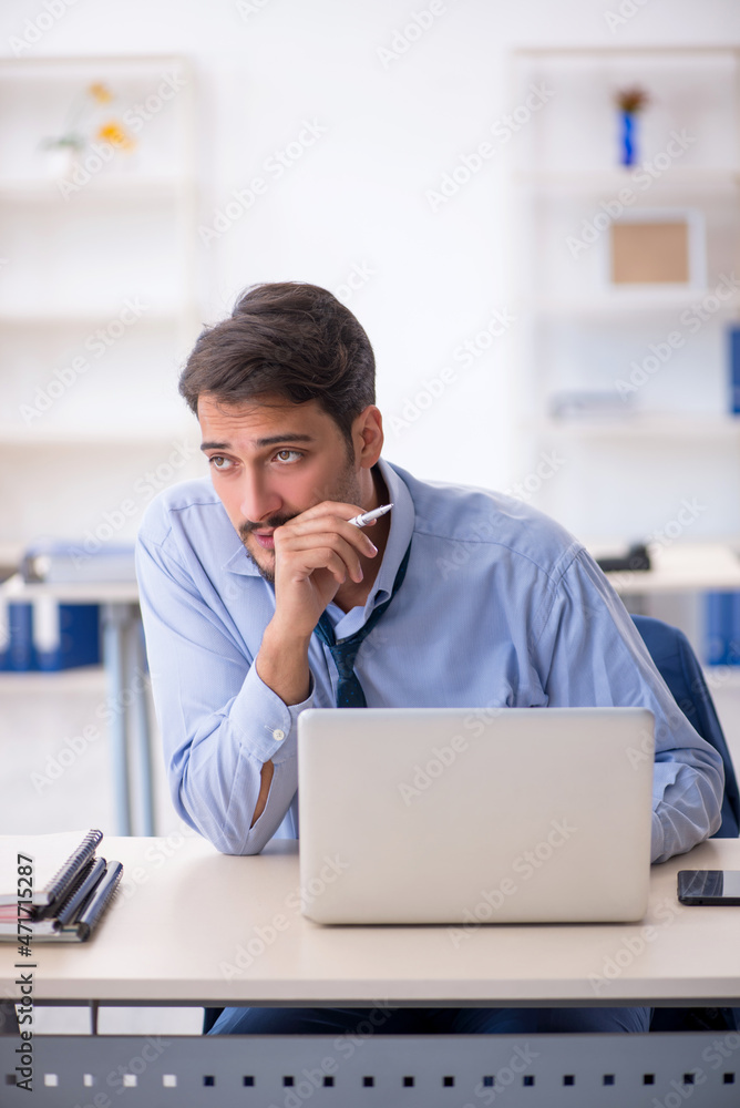 Young male employee working in the office Young male employee working in the office