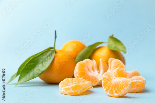 peeled tangerine and in the background a group of unpeeled tangerines,