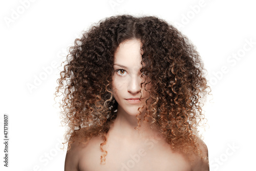 Beautiful brunette girl with long curly hair. Studio portrait on white background.