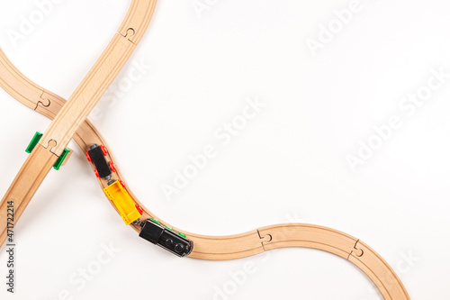 Kid toy train and wooden rails on white background. Top view