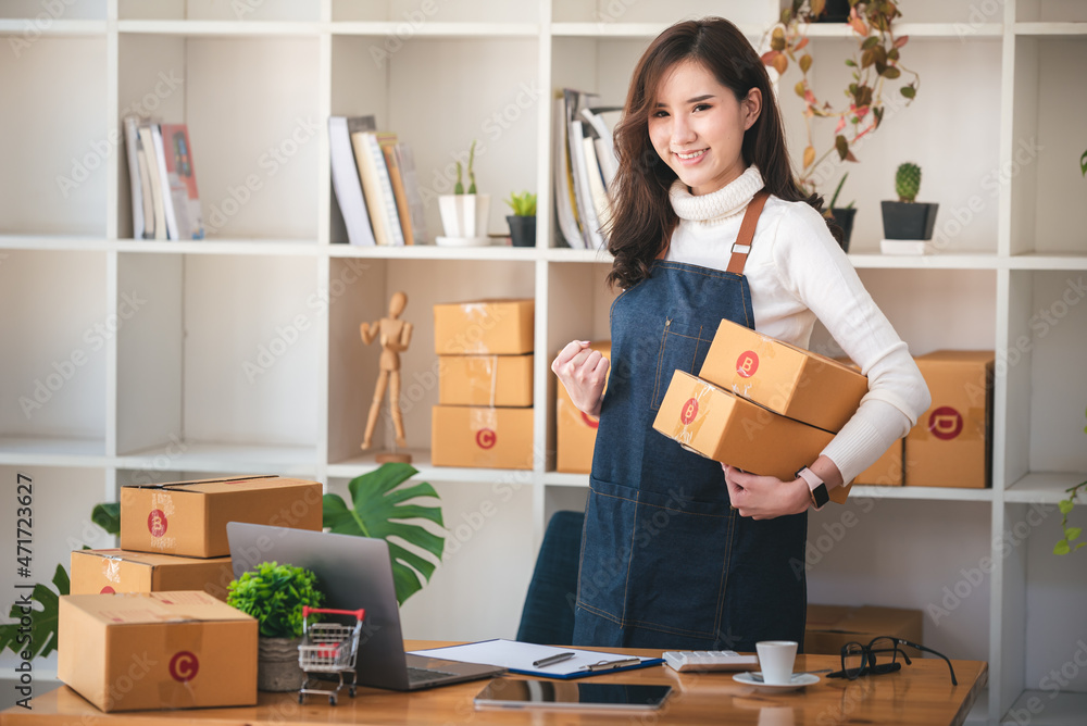 Small start-up business owners using computers at work, freelancers, saleswoman, checking production orders. Pack products for delivery to customers Small start-up business owners using computers at work, freelancers, saleswoman, checking production orders. Pack products for delivery to customers