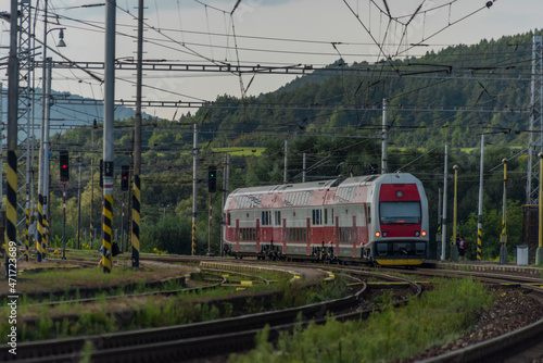 Passenger train with electric red unit in summer evening