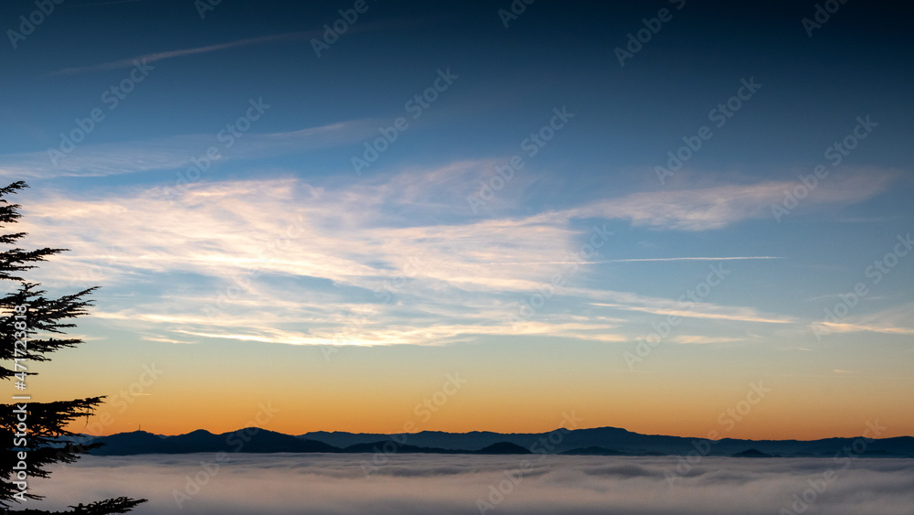 hilly mountain landscape with fog at dawn