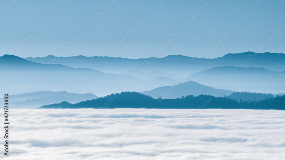 hilly mountain landscape with fog at dawn