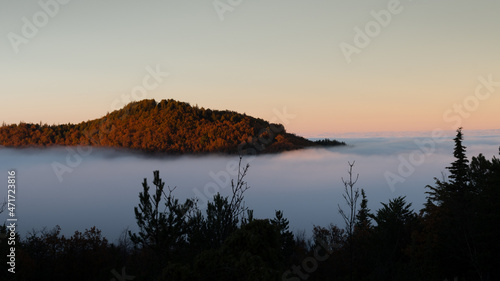 hilly mountain landscape with fog at dawn