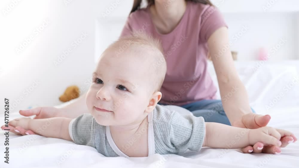 Therapist lady stretch toddler baby arms play fly wings obstetrics indoors Therapist lady stretch toddler baby arms play fly wings obstetrics indoors