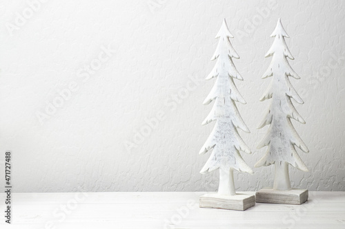 Folk art holday trees with room for text on a white washed textured wall