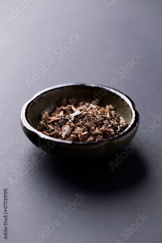 Dry root of Rhodiola rosea. Golden root, rose root. Healthy medical plant on dark paper background. Close up. Copy space.