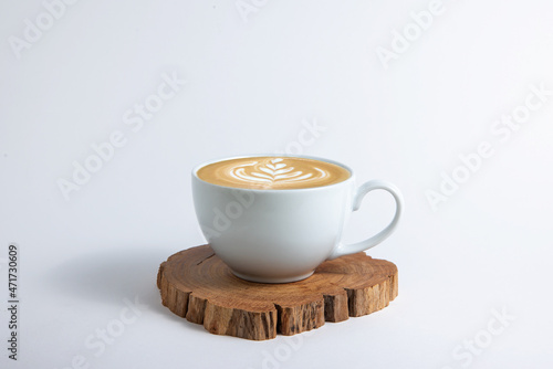 Hot cafe Latte espresso coffee in white ceramic cup on wood saucer with rosetta latte art isolated in white background. photo