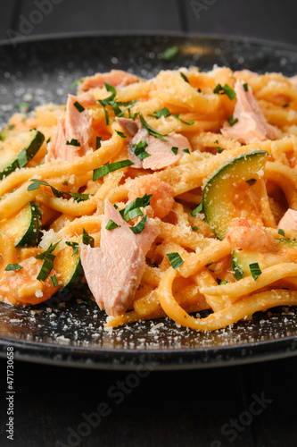 Closeup view of pasta with salmon and zuccini with grated parmesan