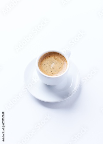 Cup of coffee on bright paper background. Copy space.
