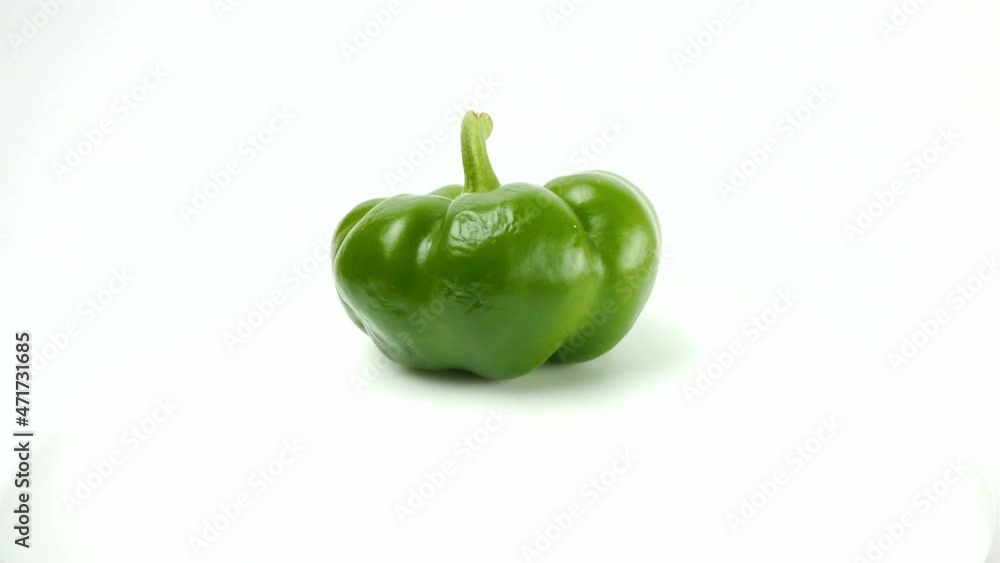 Close-up Fresh green bulgarian pepper rotates on a white background. Healthy food concept. Close-up Fresh green bulgarian pepper rotates on a white background. Healthy food concept.