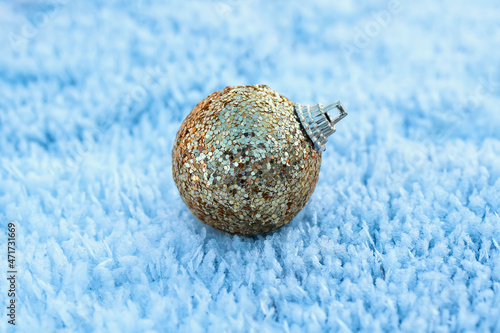 festive toy golden christmas ball lies on snow crystals in the new year's park