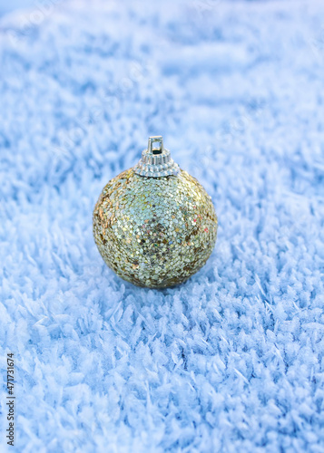 festive toy golden christmas ball lies on snow crystals in the new year's park