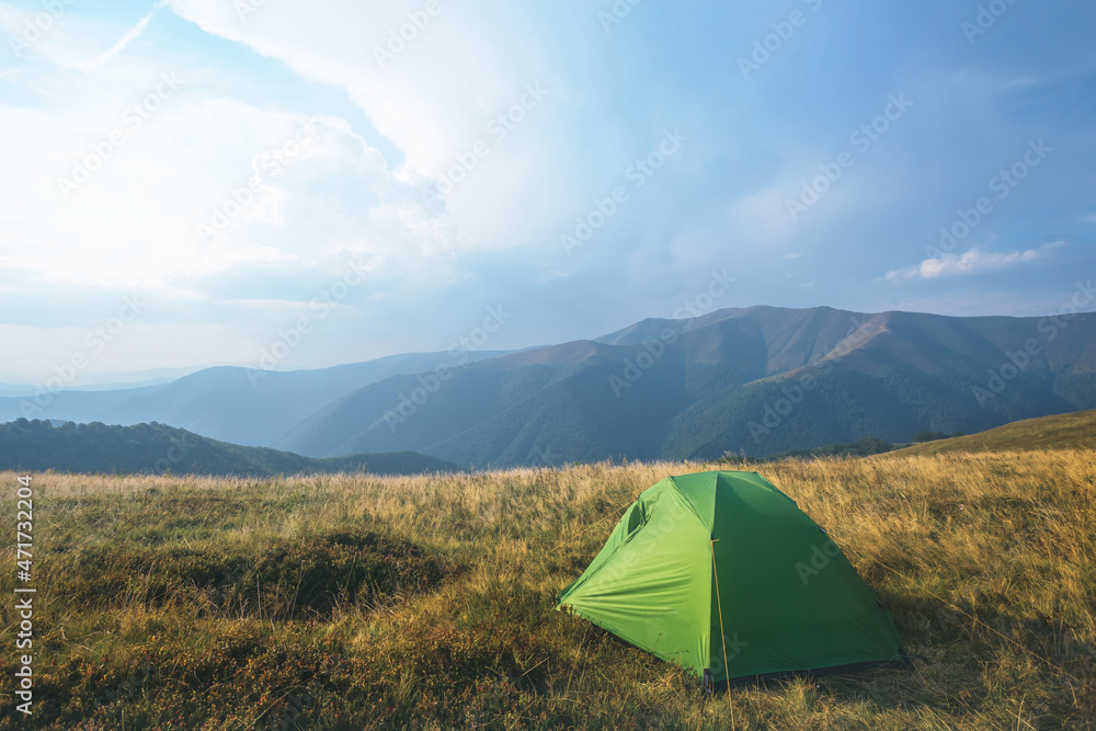 green touristic tent on mountain plateau, travel touristic camp in mountain