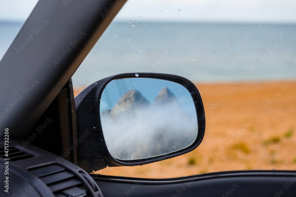 view from car to sea beach with mount top reflecter in side mirror