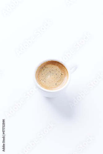 Cup of coffee on bright paper background. Copy space. 