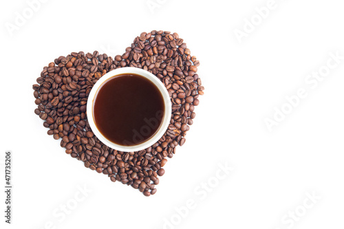 The concept of love for coffee. A yellow paper cup of coffee among coffee beans folded in the shape of a heart, on a white isolated background.
