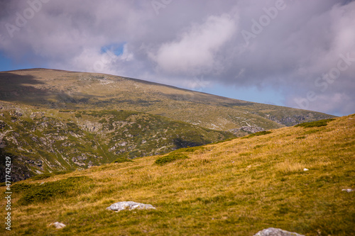 Bulgarian landscape of a mountain peak in Rila mountain.Beautiful nature landscape.Green grass and blue sky with clouds. High quality photo © Viktorio