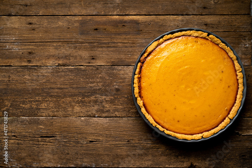 pumpkin American pie on a wooden background, top view, copy space