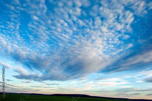 Panorama of dawn fire in the sky above the natural pasture. Golden red clouds just before sunrise. Picturesque landscape at sunrise. Beauty in nature